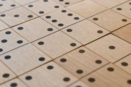 Playing dominoes on a wooden table. Leisure games concept. Domino abstract background. Selective focus.の写真素材