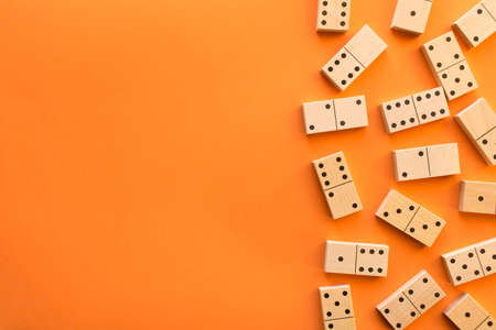 Playing dominoes on a orange table. Leisure games concept. Domino effect.の写真素材