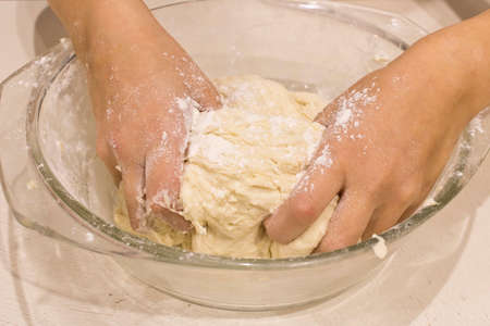 Hands of a little girl with dough. The concept of preparation for Easter. Close up