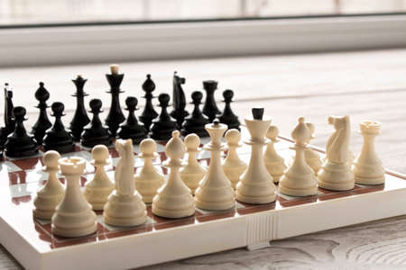 Chessboard with figures on a wooden table. Selective focus