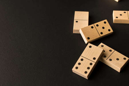 Playing dominoes on a dark background. Leisure games concept. Domino effect. Selective focus
