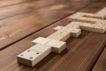 Playing dominoes on a wooden table. Leisure games concept. Selective focusの写真素材