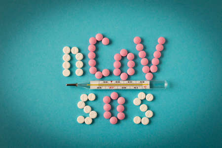 Coronavirus. Thermometer and label with pills on a blue background. The concept of virus protectionの写真素材