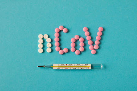 Coronavirus. Inscription with pills on a blue background. The concept of protection from virusesの写真素材