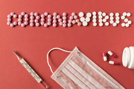 Coronavirus. The inscription coronavirus pills, medical supplies on a red background. The concept of protection from the virus. Selective focusの写真素材