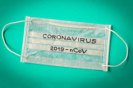 Coronavirus. The inscription coronavirus on the protective medical mask. On blue background. The concept of protection from viruses.の写真素材