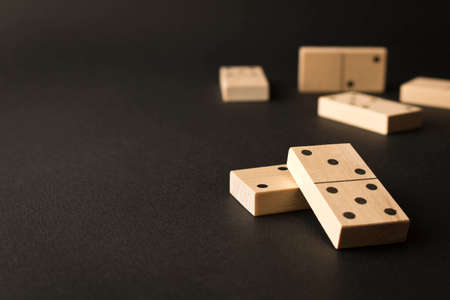 Playing dominoes on a dark background. Leisure games concept. Domino effect. Selective focus.の写真素材