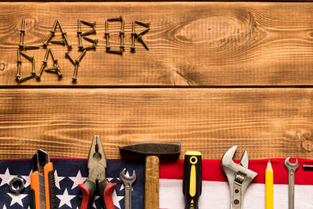 Labor day. American flag and various tools on a wooden background. The concept of labor day. Empty...
