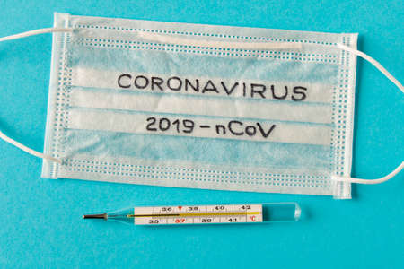 Coronavirus. The inscription coronavirus on the protective medical mask. On blue background. The concept of protection from viruses.の写真素材