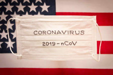 CORONAVIRUS. Protective medical mask on the background of the American flag . Concept of protection against coronavirusの写真素材