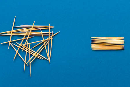 Lots of wooden toothpicks on a blue background. The concept of order and chaosの写真素材