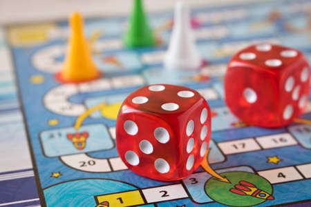 Multi-colored game chips with dice on the playing board. Concept of leisure games 