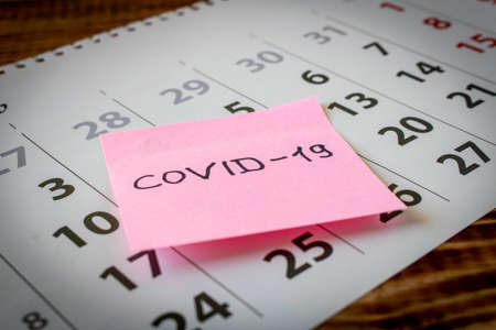 CORONAVIRUS. Sticker with the inscription COVID-19 on the calendar sheets. The concept of quarantine. Selective focusの写真素材