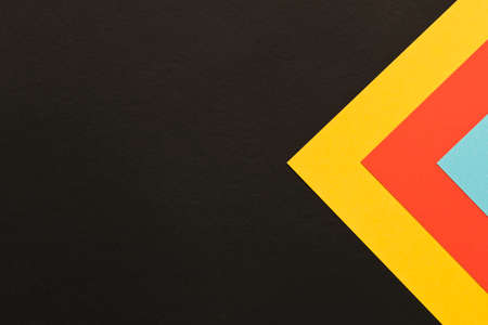 Multi-colored abstract geometric background. Colored sheets of paper on a dark background. Trending...