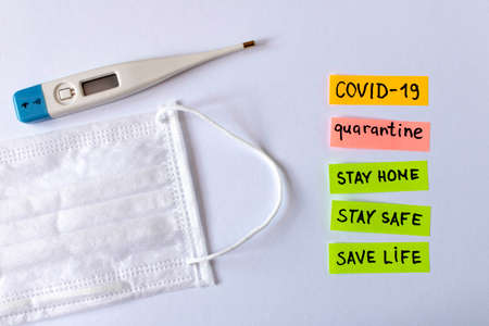 CORONAVIRUS. Protective medical mask and stickers with the words COVID-19, quarantine. Close up....