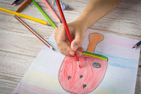 The girl draws with colored pencils. Close upの写真素材