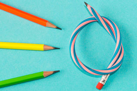 Simple pencils and flexible pencil on a blue background. Close up. Selective focus