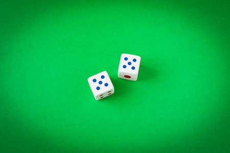 Dice on a green playing table. Close up. The concept of luck in gambling