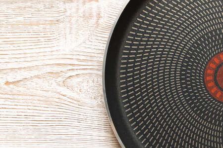A new metal frying pan on a wooden table. Close upの写真素材