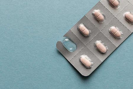 Package of pills on a blue background. Close up. Selective focusの写真素材