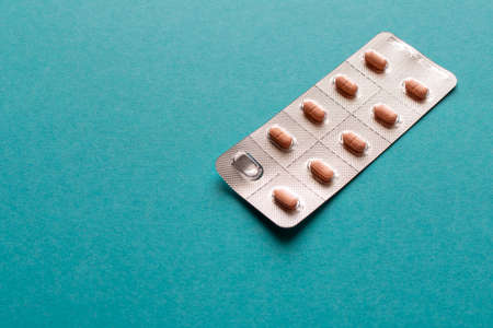 Package of pills on a blue background. Close up. Selective focusの写真素材