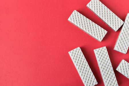 A few waffles with chocolate on an red background. Selective focusの写真素材