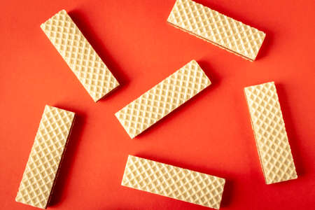 A few waffles with chocolate on an red background. Selective focus