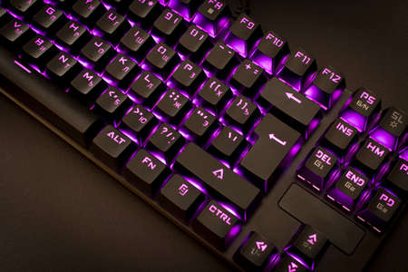 Black gaming keyboard with backlight. Close up. Selective focus