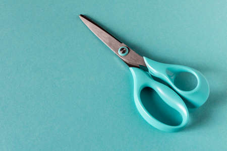 Blue modern scissors on a blue background. Close upの写真素材