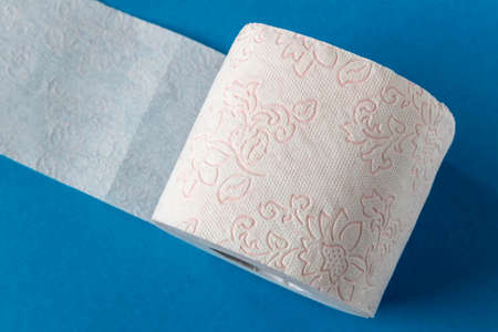 Toilet paper roll on a blue background. Close up