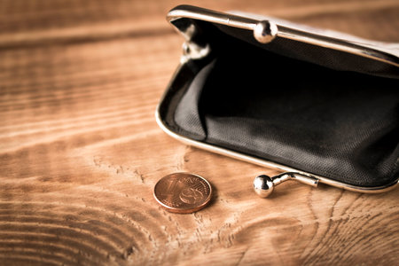 Wallet with coins on a wooden table. Close up. Selective focus. The concept of poverty