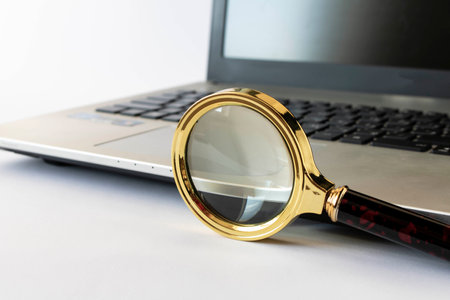 Magnifying glass and laptop on a light background. The concept of searching for information on the Internet. Selective focusの写真素材