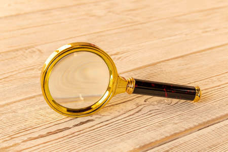 A magnifying glass on a wooden table. The concept of information search. Selective focusの写真素材
