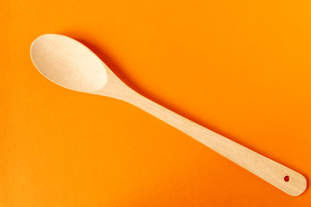 Wooden spoon on an orange background. Close-upの写真素材