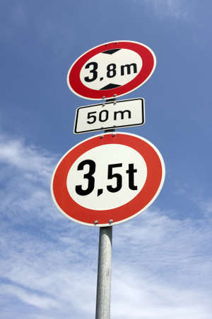 roadsign height restrictions under cloudy blue sky