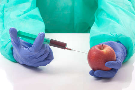 Doctor with syringe and apple over whiteの写真素材