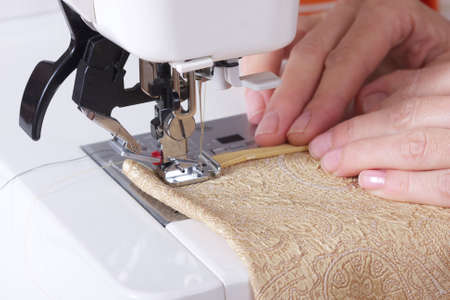 woman sews on the sewing machineの写真素材