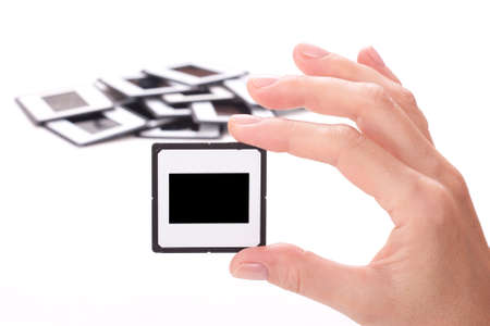 female hand holding a Photo frame over white backgroundの写真素材