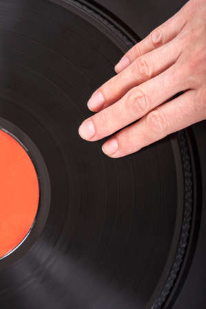 Female hand on vintage vinyl recordの写真素材