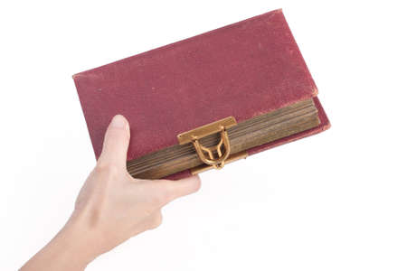 female hand holding an old book with lock over whiteの写真素材