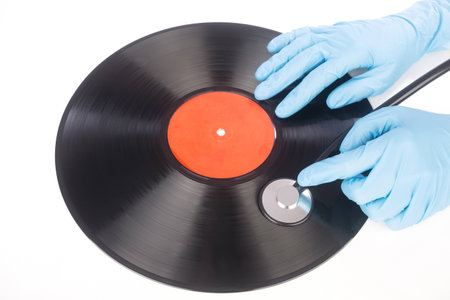 hand with a stethoscope on the surface of a vinyl recordの写真素材