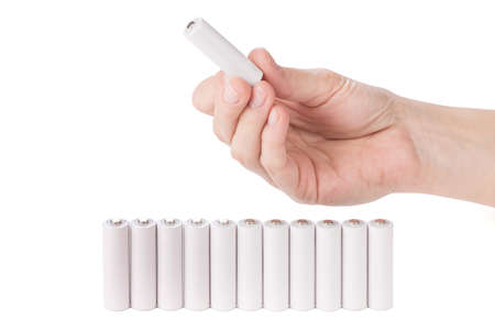female hand holding a AA battery over whiteの写真素材