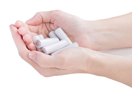 female hands are kept in an armful batteries over whiteの写真素材