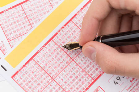 male hand filling fountain pen lotto ticketの写真素材