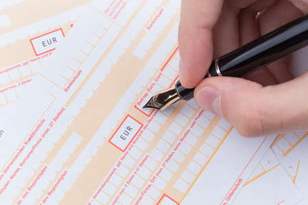 male hand filling fountain pen Remittance slip