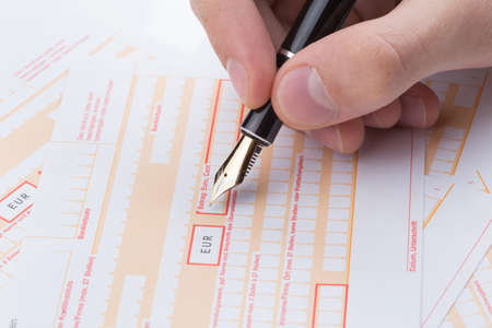 male hand filling fountain pen Remittance slip