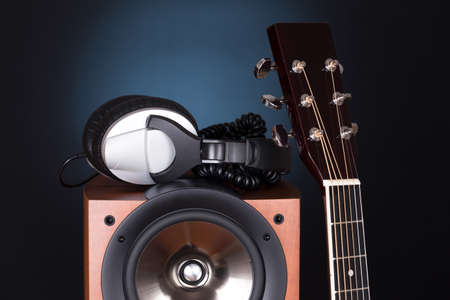 high loudspeaker tower with acoustic guitar over black backgroundの写真素材