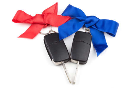 Car keys with red and blue bows over white backgroundの写真素材