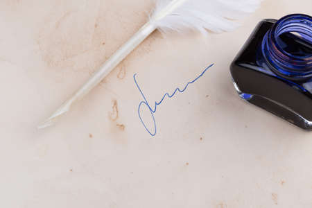 White Feather pen and ink bottle on old paperの写真素材