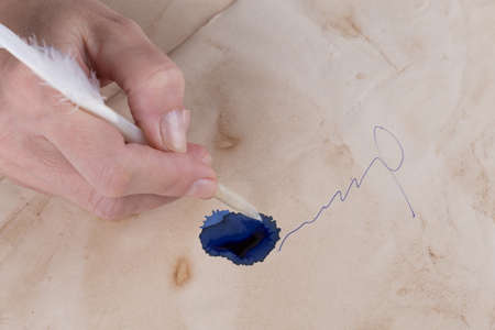 female hand sign with a quill on the old paperの写真素材